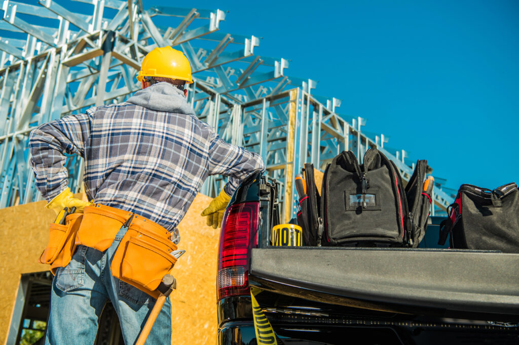 contractors insurance service man with tool belt looking at building